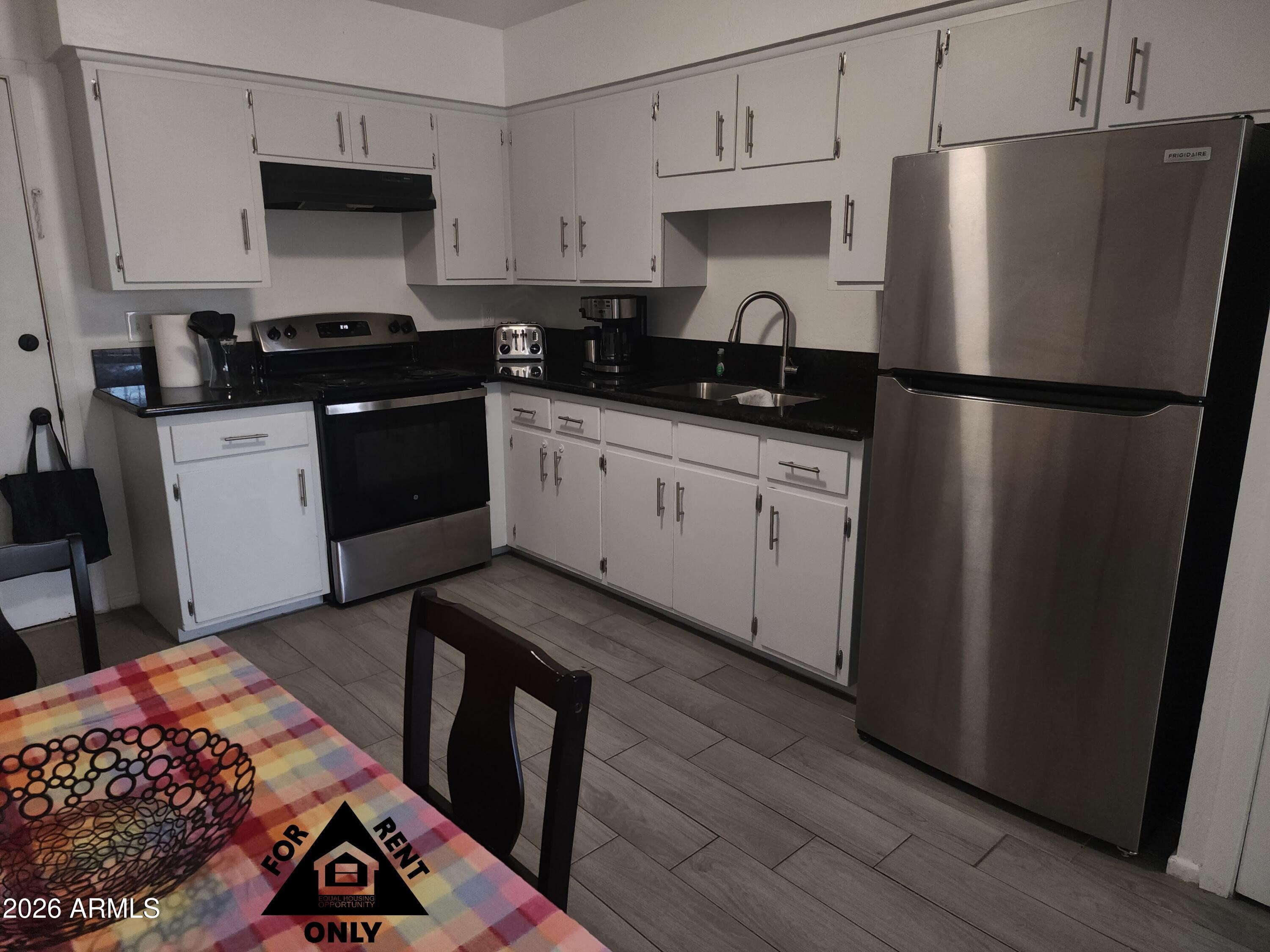2001 West Turney Avenue, Unit 6 Phoenix, AZ 85015 - Photo 3 of 10 a kitchen with a sink a refrigerator and cabinets