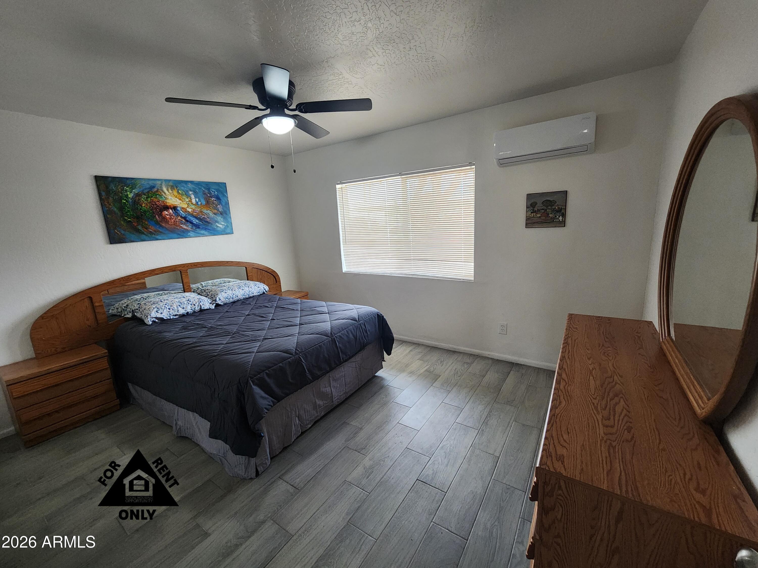 2001 West Turney Avenue, Unit 6 Phoenix, AZ 85015 - Photo 4 of 10 a bedroom with a bed and wooden floor