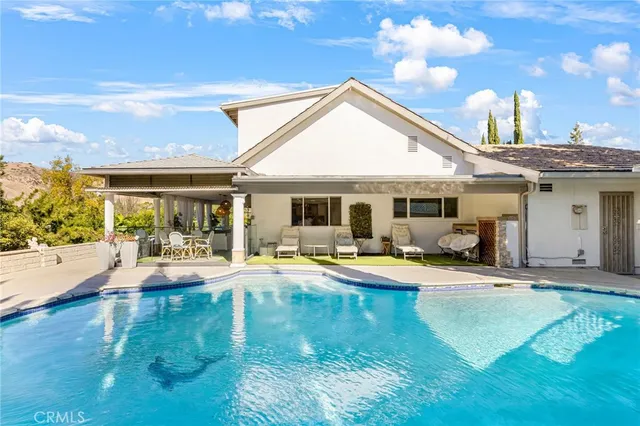 a view of a house with swimming pool and sitting area