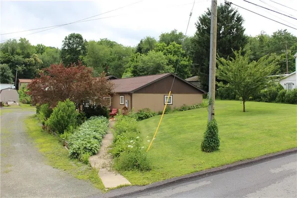 a view of a house with a yard and basketball court