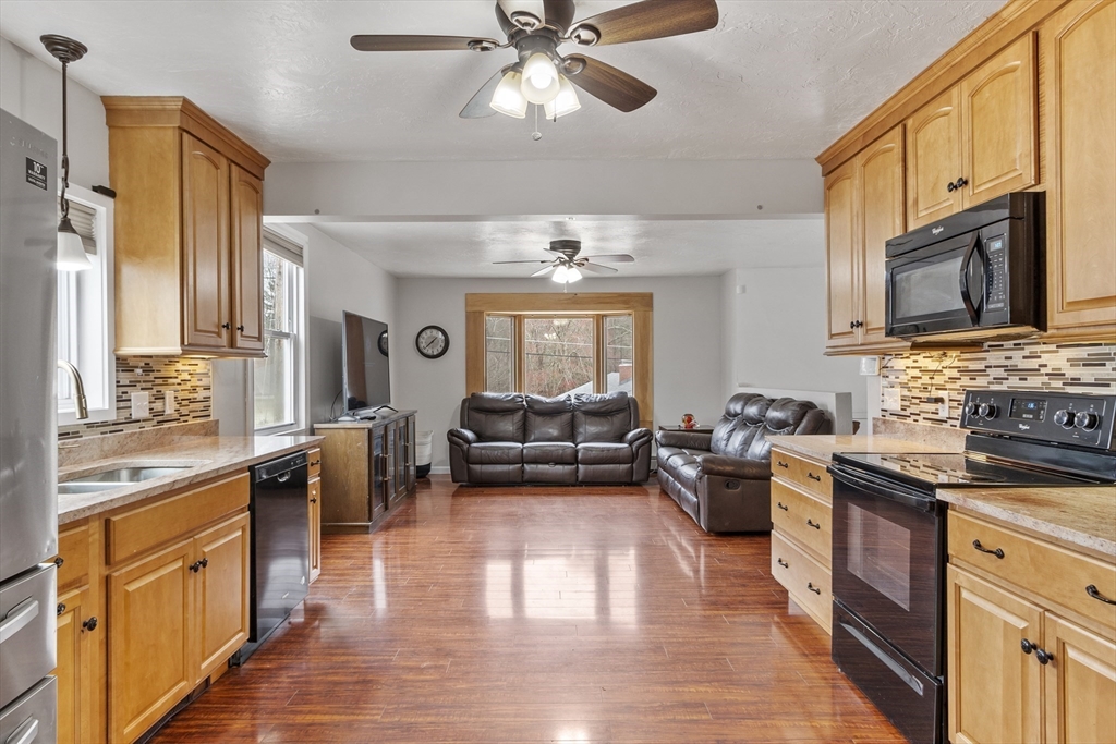 53 Laurel Hill Road Southbridge, MA 01550 - Photo 5 of 28 a large kitchen with stainless steel appliances granite countertop a stove a sink dishwasher a dining table and chairs with wooden floor