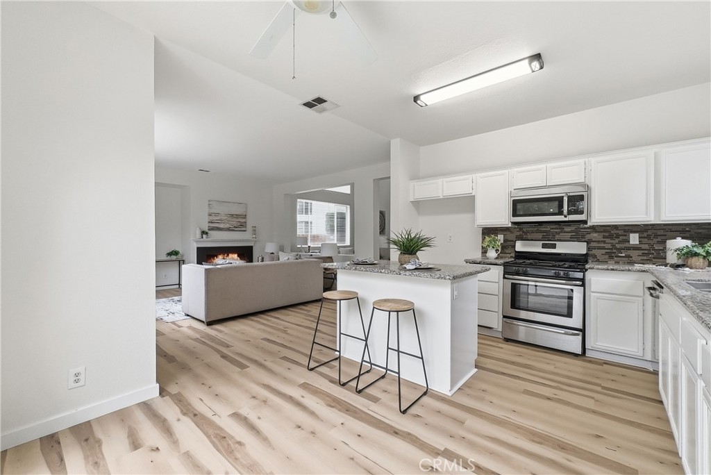 7522 Calais Court Rancho Cucamonga, CA 91730 - Photo 8 of 20 a kitchen with granite countertop a stove a sink and a refrigerator