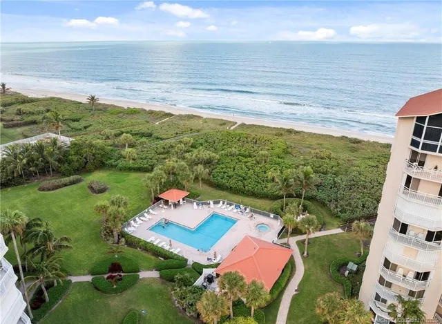 a living room with couches and kitchen view with wooden floor