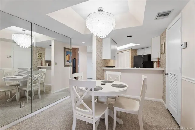 a view of a dining room with furniture and chandelier
