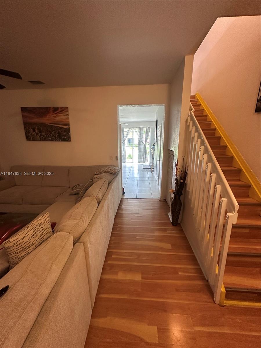 8922 Southwest 18th Street, Unit 8922 Miramar, FL 33025 - Photo 8 of 22 a view of a hallway with wooden floor and staircase