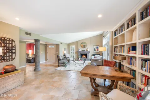 a living room with fireplace furniture and a book shelf
