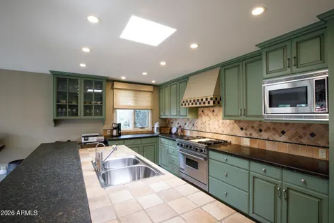 a kitchen with stainless steel appliances granite countertop a stove a sink and a refrigerator