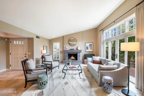 a living room with furniture a fireplace and a large window