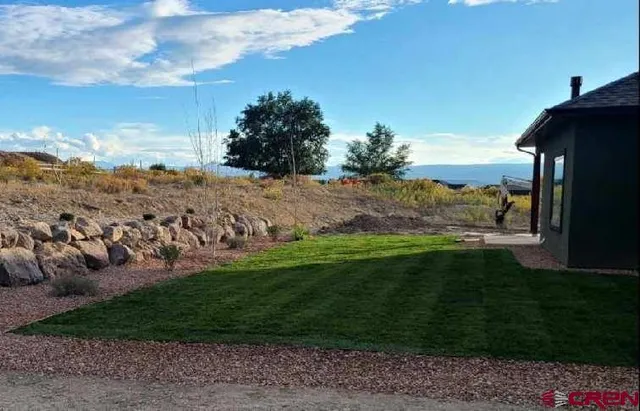 a view of a field with a house in the background