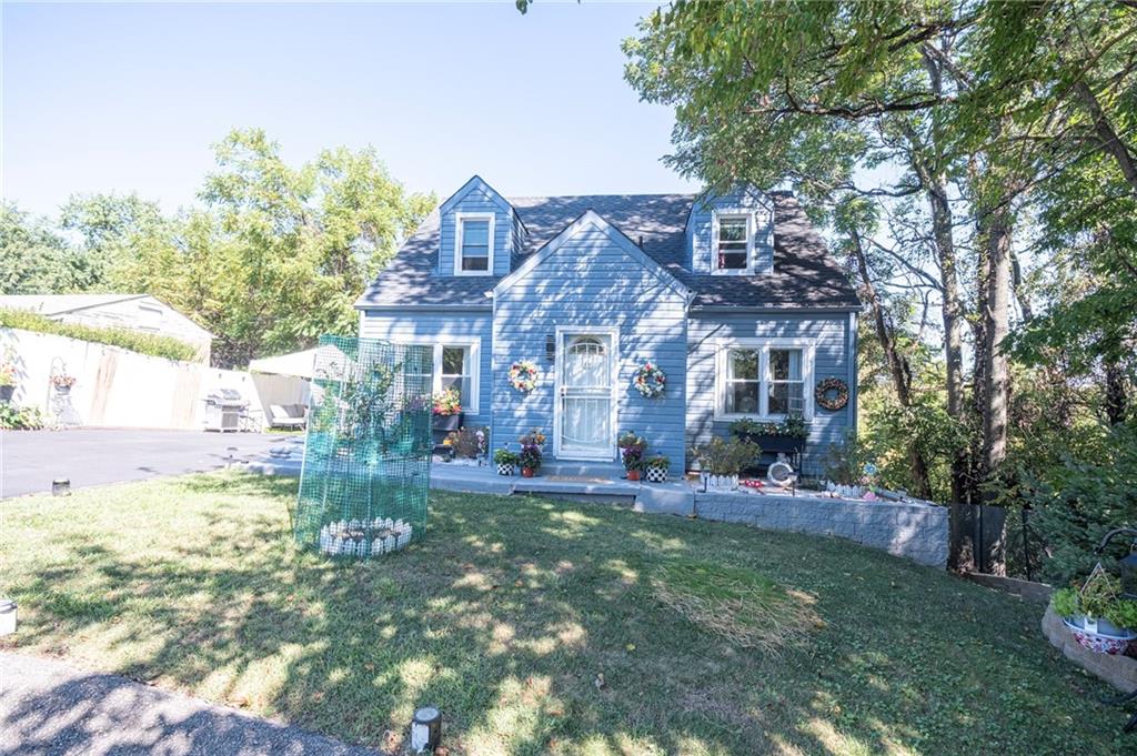a view of a house with a big yard and large trees