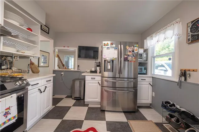 a kitchen with stainless steel appliances a refrigerator sink and microwave