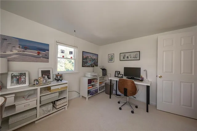 a view of a workspace with furniture and a window