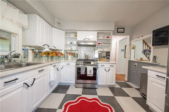 a kitchen with stainless steel appliances a stove a sink and a refrigerator