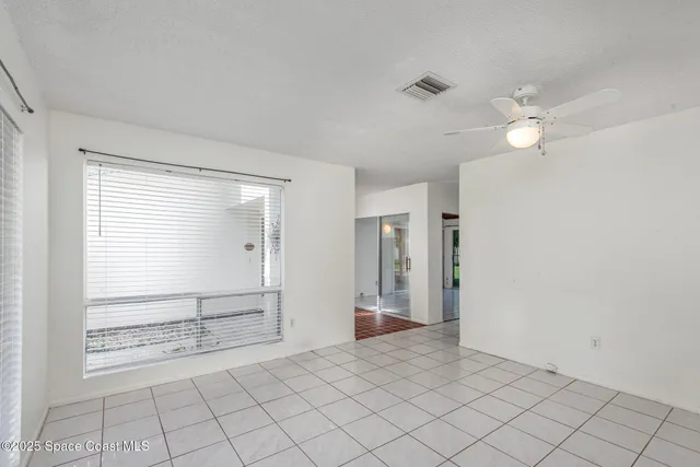 an empty room with fan and windows