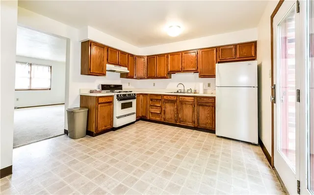 a kitchen with stainless steel appliances granite countertop a stove a refrigerator a sink dishwasher and a refrigerator