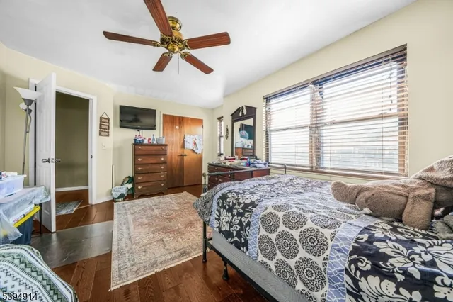 a spacious bedroom with a bed a dresser and a large window