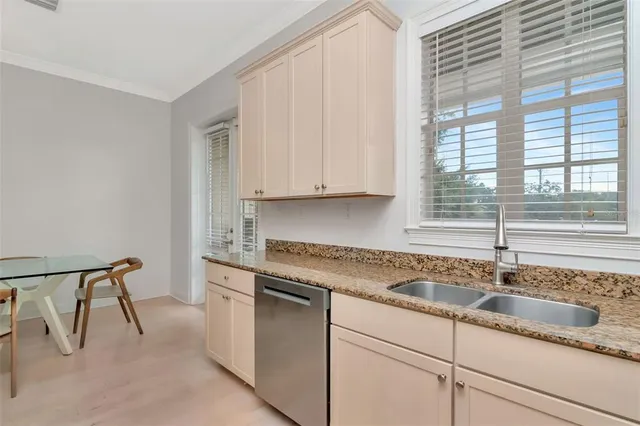 a kitchen with granite countertop white cabinets and a sink