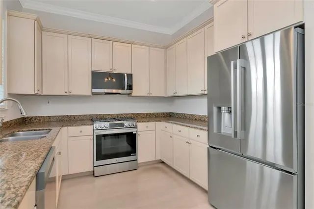 a kitchen with stainless steel appliances granite countertop a refrigerator stove and cabinets