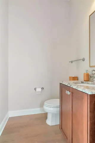 a bathroom with a granite countertop sink a toilet and a mirror