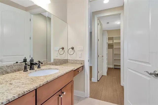 a bathroom with a granite countertop sink and a mirror