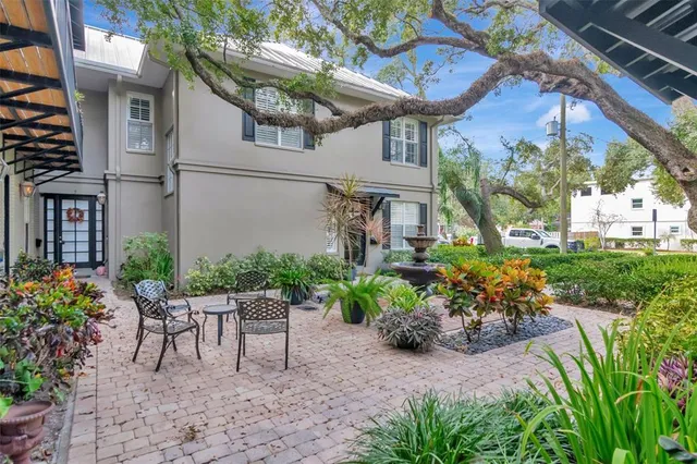 a patio with table and chairs and potted plants