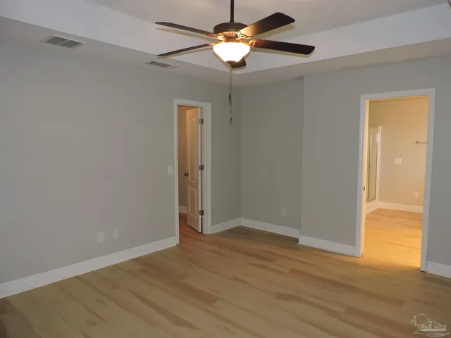 a view of room with hardwood floor and a ceiling fan