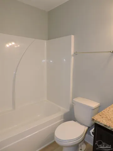 a white toilet and tub next to a bathroom sink