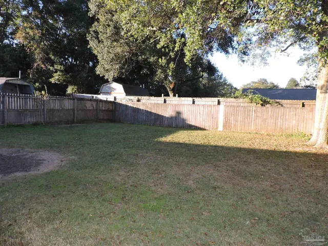 a view of a yard with wooden fence