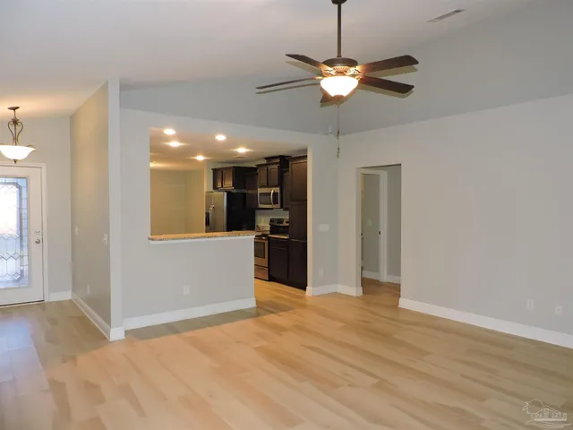 a view of a livingroom with a ceiling fan window and wooden floor