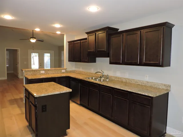 a kitchen with granite countertop a sink and cabinets