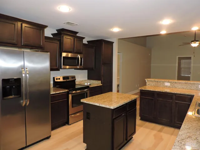a kitchen with stainless steel appliances granite countertop a refrigerator and a sink