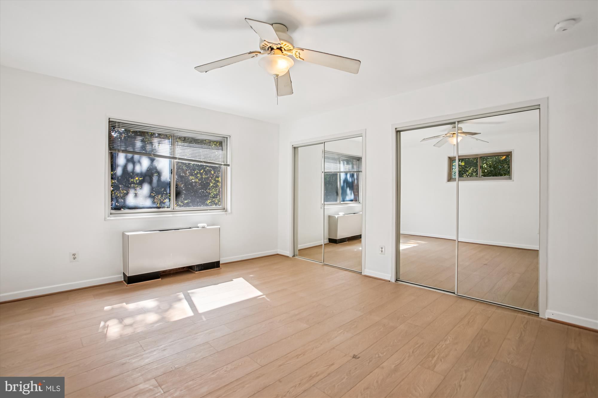 3900 Tunlaw Road Northwest, Unit 509 Washington, DC 20007 - Photo 19 of 36 a view of empty room with wooden floor and fan
