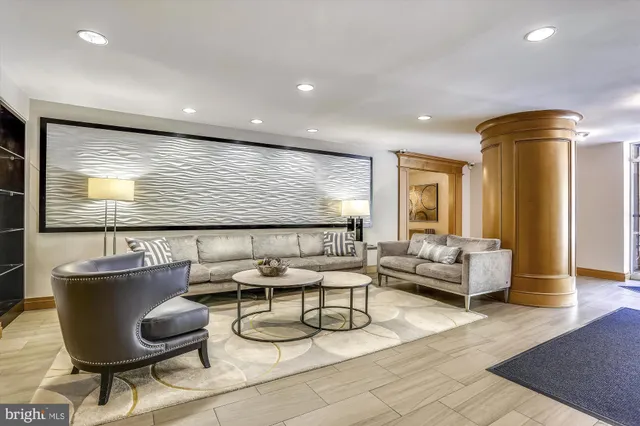 a living room with furniture kitchen view and a large window
