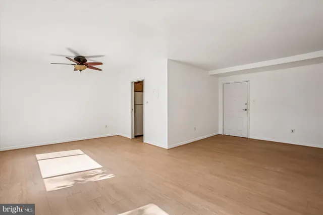 a view of a room with a ceiling fan and window