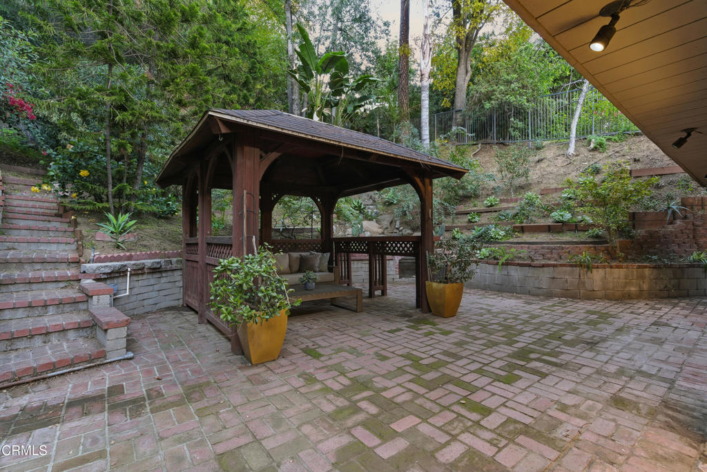 640 Chaparral Road Sierra Madre, CA 91024 - Photo 23 of 25 a view of a deck with table and chairs potted plants with wooden fence