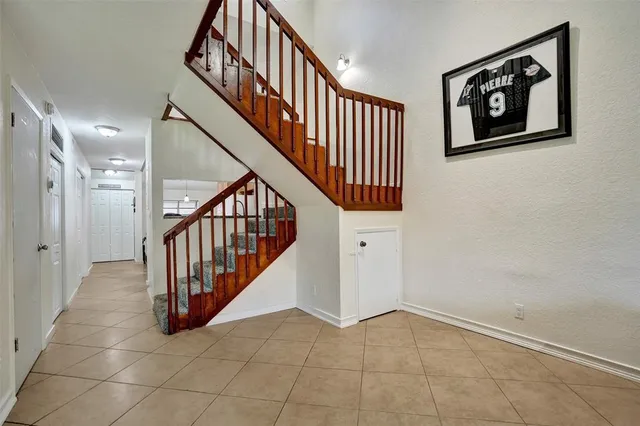 a view of staircase with lots of frames on wall and a window