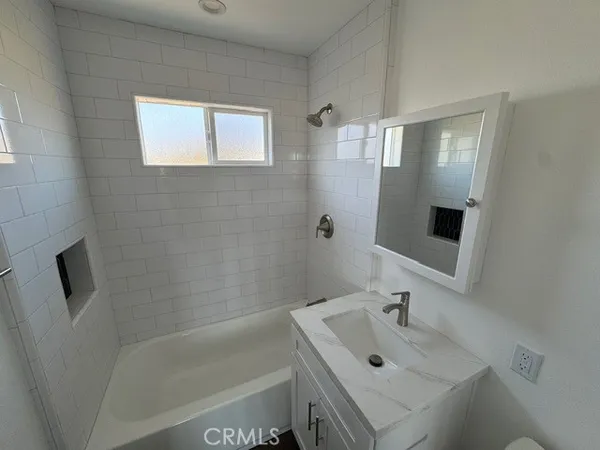 a bathroom with a tub a sink and mirror