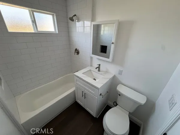 a bathroom with a sink mirror vanity and toilet