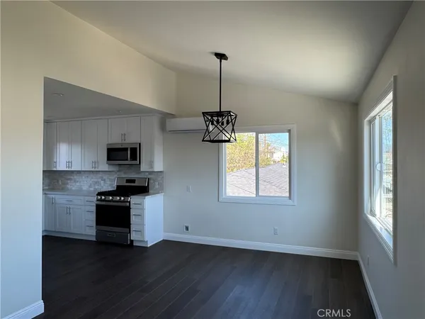 a kitchen with stainless steel appliances granite countertop a sink a stove a microwave and wooden floor