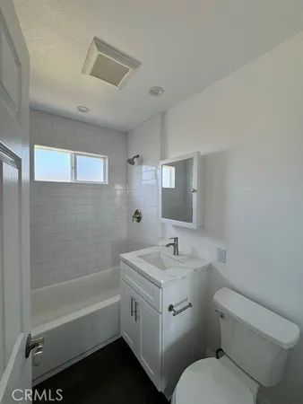 a bathroom with a sink toilet vanity and bathtub