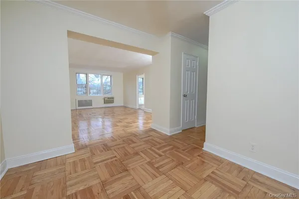 a view of a hallway with wooden floor and a living room