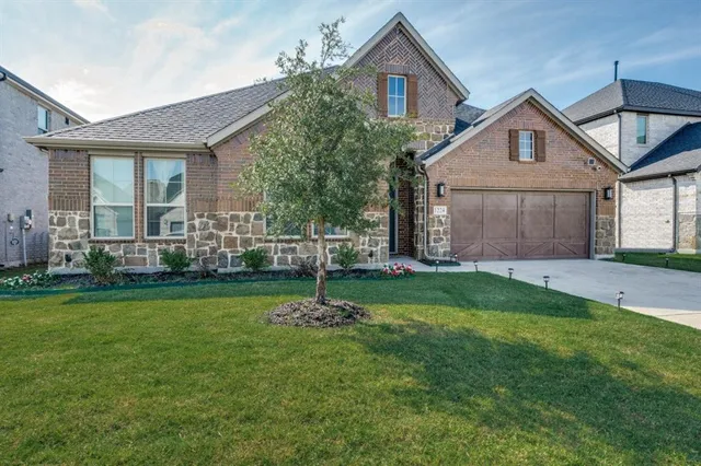 a front view of a house with a garden and yard