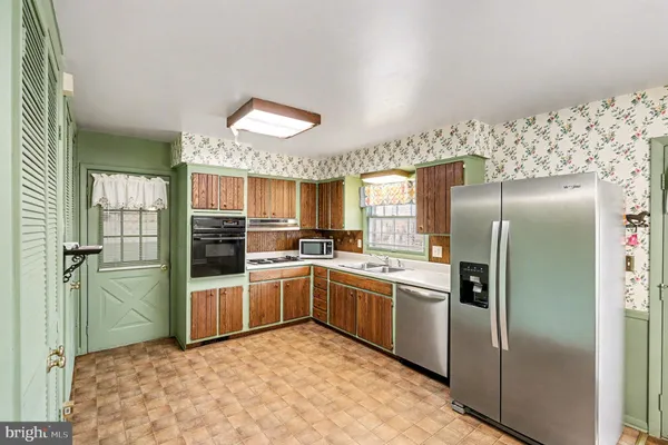 a kitchen with stainless steel appliances granite countertop a refrigerator and a sink