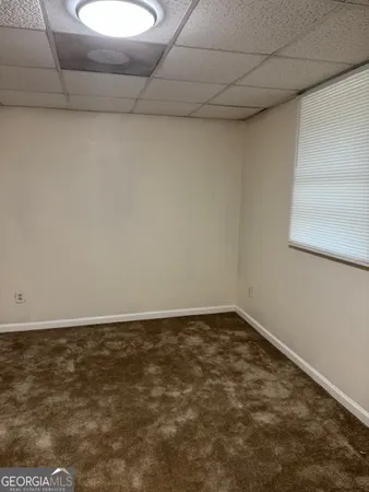 a view of a room with an empty space and a window