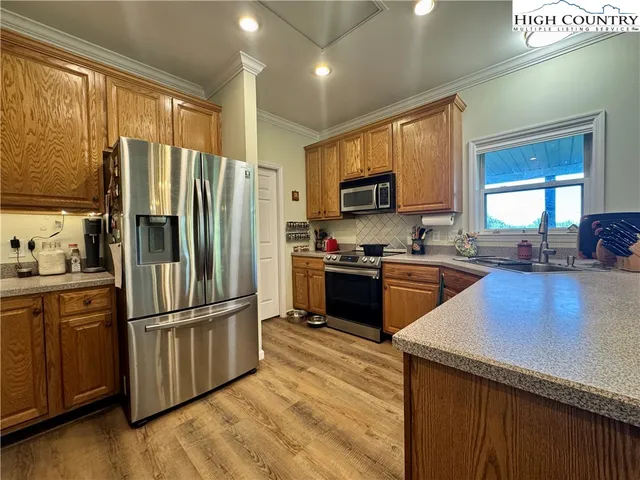 a kitchen with stainless steel appliances granite countertop a refrigerator stove and a window