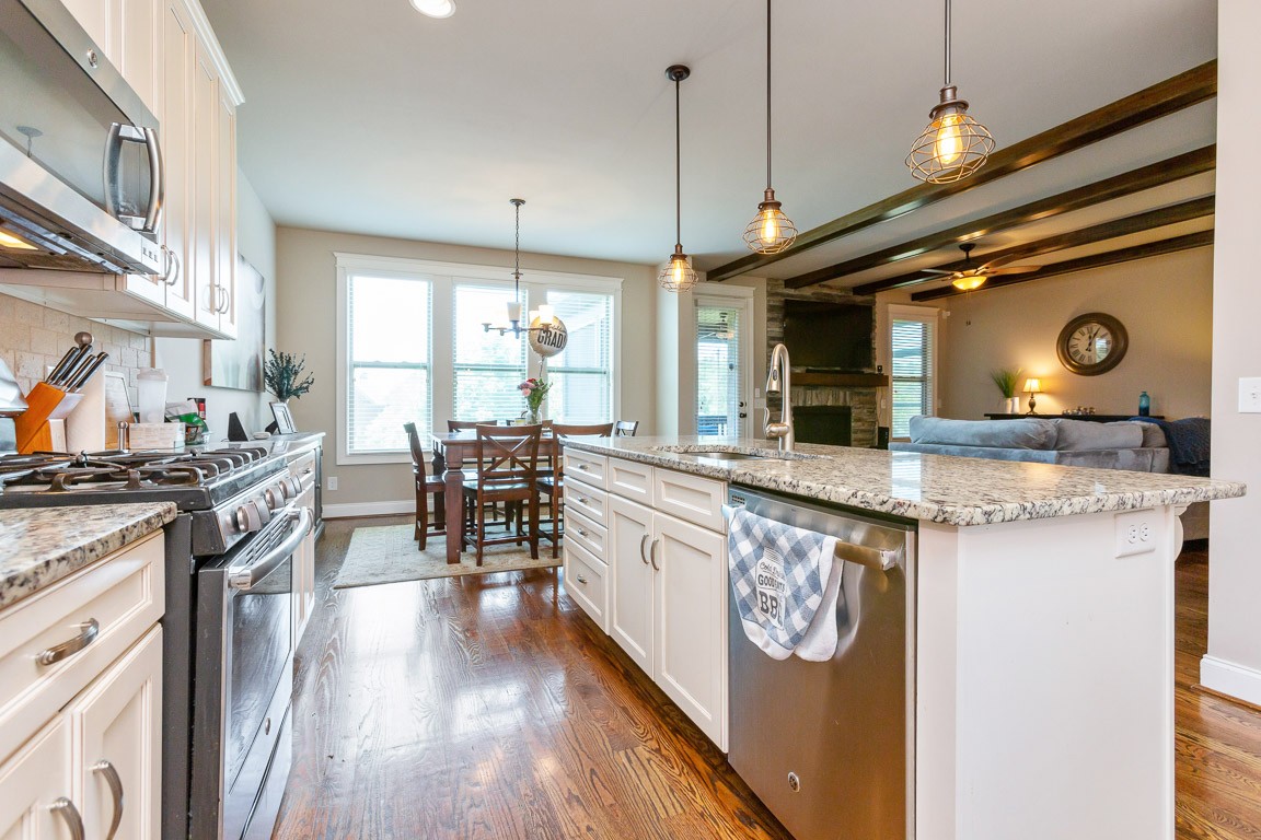 3501 Earhart Road Mount Juliet, TN 37122 - Photo 14 of 42 a kitchen with granite countertop a stove a sink a dining table and chairs with wooden floor