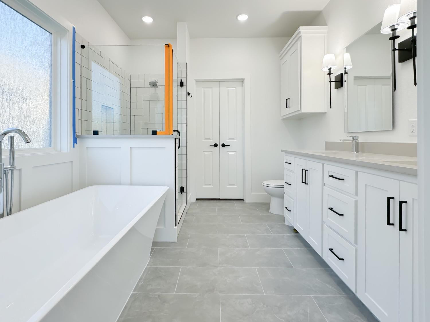 1301 Abbey Road Wolfforth, TX 79382 - Photo 15 of 24 a spacious bathroom with a double vanity sink a mirror and a bathtub