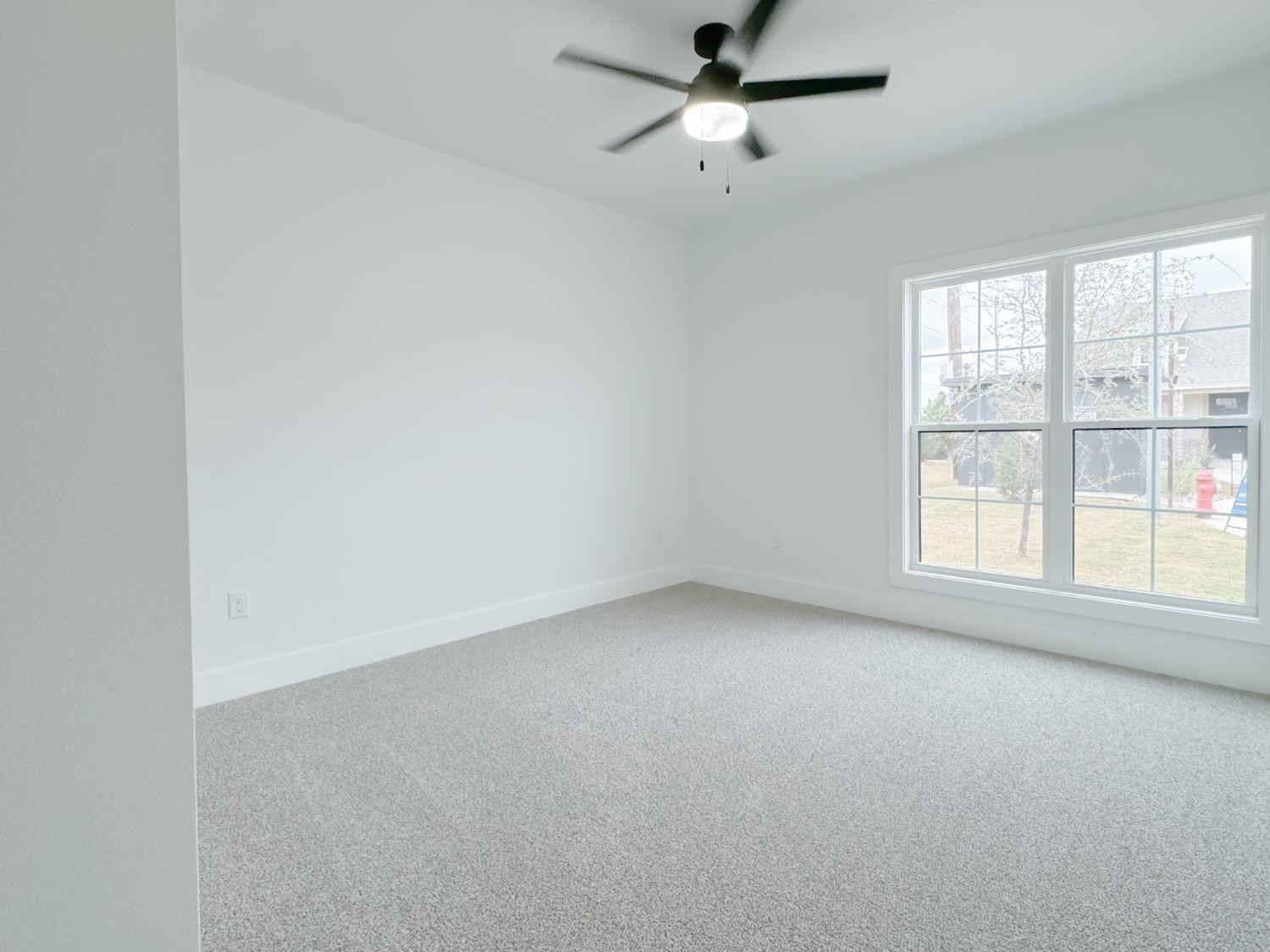 1301 Abbey Road Wolfforth, TX 79382 - Photo 20 of 24 an empty room with a window and a fan