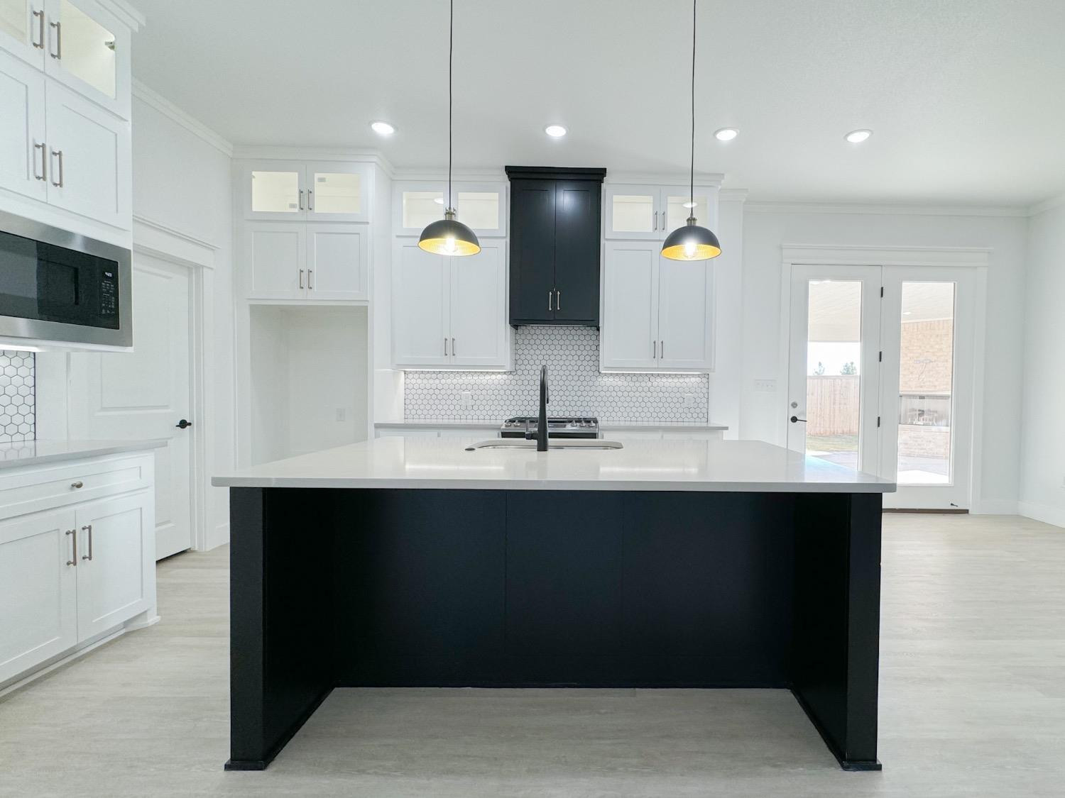 1301 Abbey Road Wolfforth, TX 79382 - Photo 6 of 24 a kitchen with a sink refrigerator and microwave