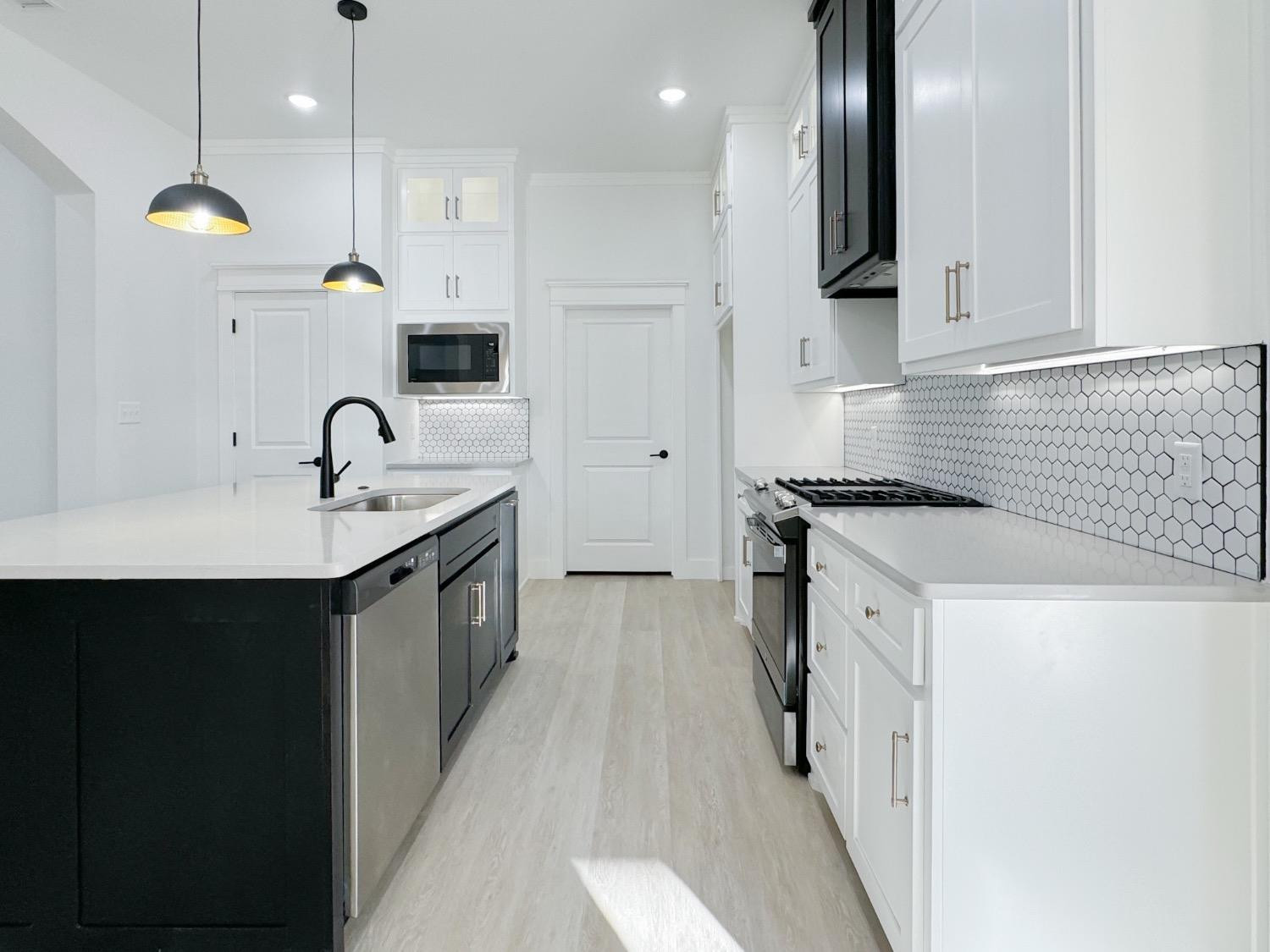 1301 Abbey Road Wolfforth, TX 79382 - Photo 8 of 24 a kitchen with a sink stove and refrigerator